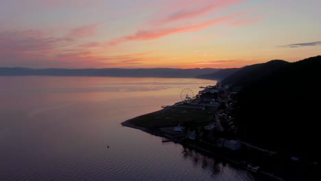 sunset over a lake with city and mountains