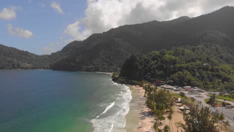 Maracas Bay Beach with waves crashing on the shoreline with Mount El Tecuche in the background