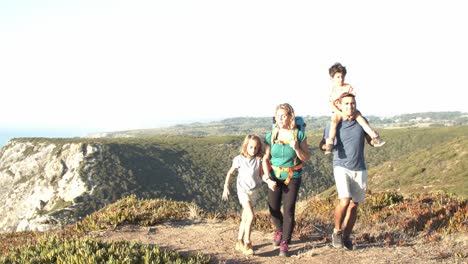 feliz pareja de padres e hijos caminando por el camino en el mar