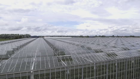 4k aerial close-up forward shot over an glass greenhouse in the netherlands