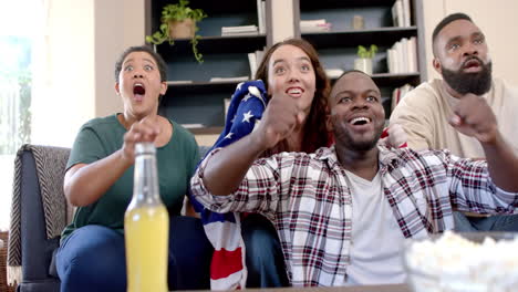 group of friends cheering and celebrating while watching sports game at home