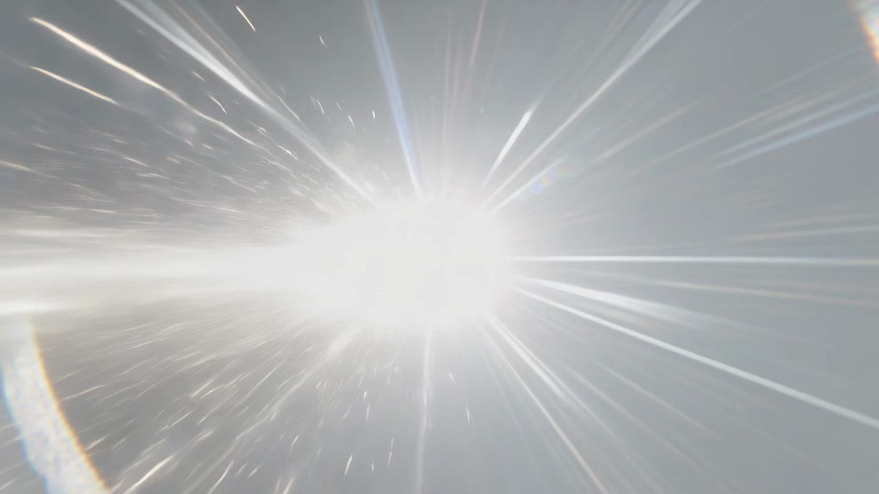 Pointing camera upward, sun causing lens bloom with radial rays horizontal streaks in pale sky