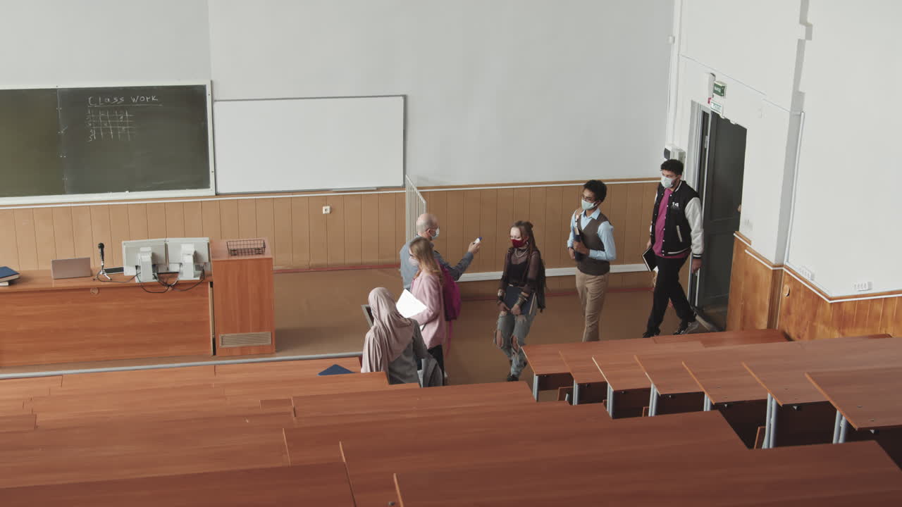 Professor Measuring Students Temperature in Lecture Hall