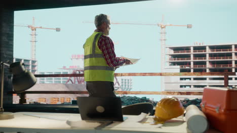Engineer or architect overlooks a construction site from an office window