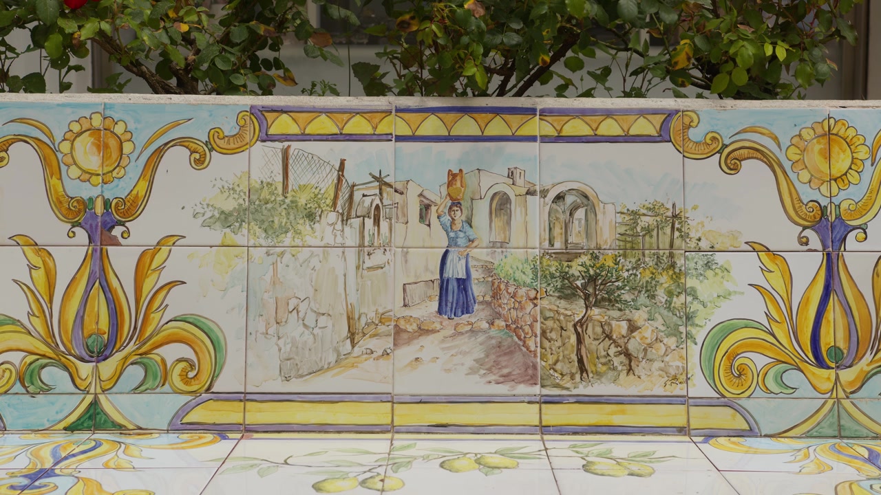 Nahaufnahme einer lebendigen, künstlerischen Bank in Anacapri, mit einzigartigen Fliesenmustern in kräftigen Farben, die den Charme des Alltags widerspiegelt, Capri, Italien.