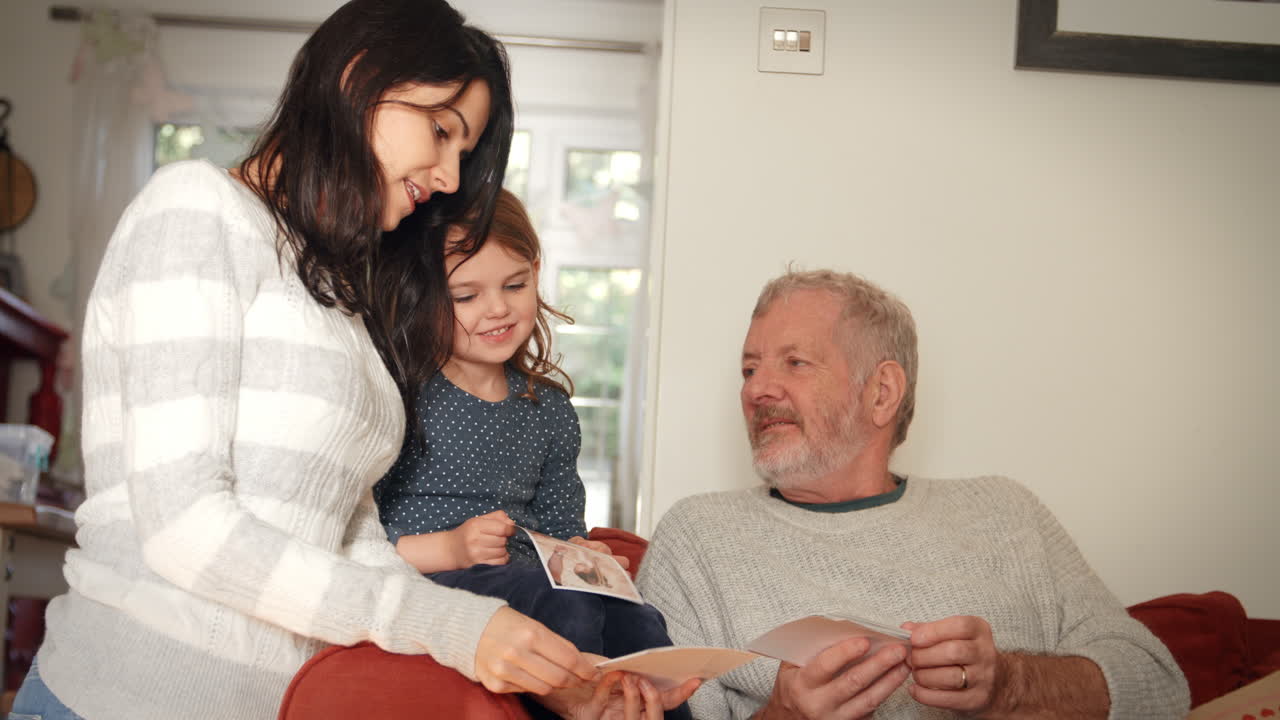 familia de varias generaciones en casa mirando fotografías