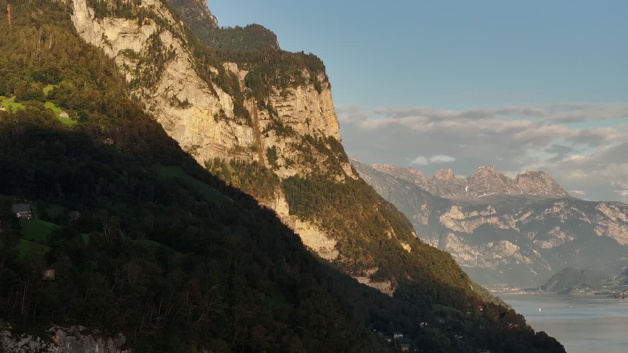 la luz del sol ilumina los escarpados acantilados que dominan el lago walensee, con picos de montañas lejanos cerca de wessen, amden, quinten, mols y walenstadt, suiza