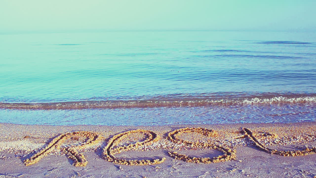 Inscription rest on sand, the beach. Inscription on sand, the beach
