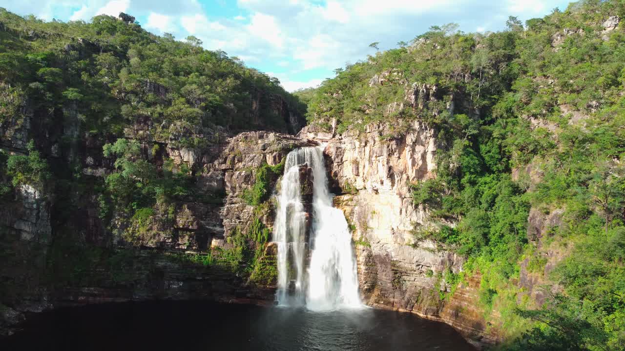 exuberante cascada de montaña con cielo azul en bosque nativo