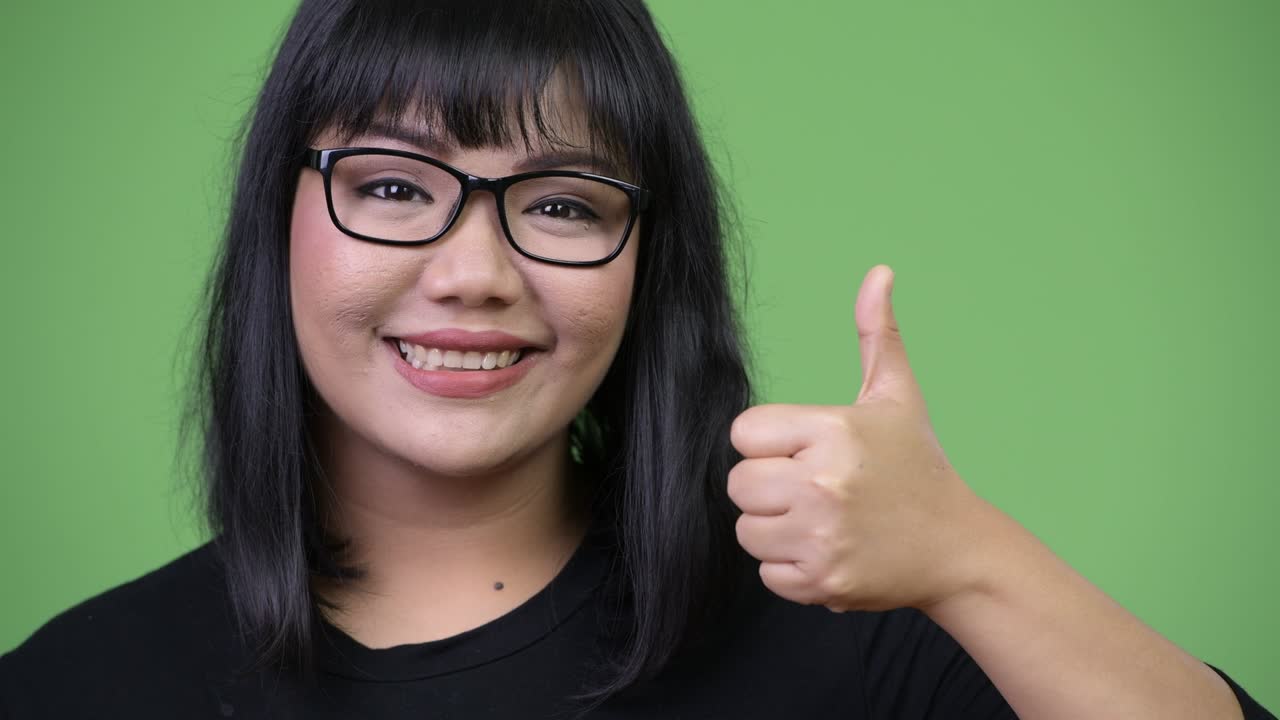 Beautiful Asian businesswoman giving thumbs up