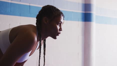 Mixed-race-woman-resting-in-boxing-gym