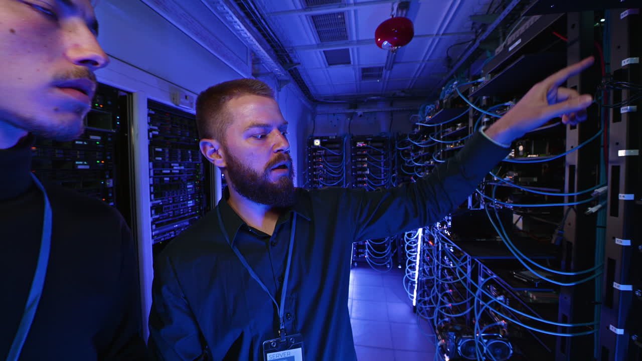 Two men analysing data in a server room