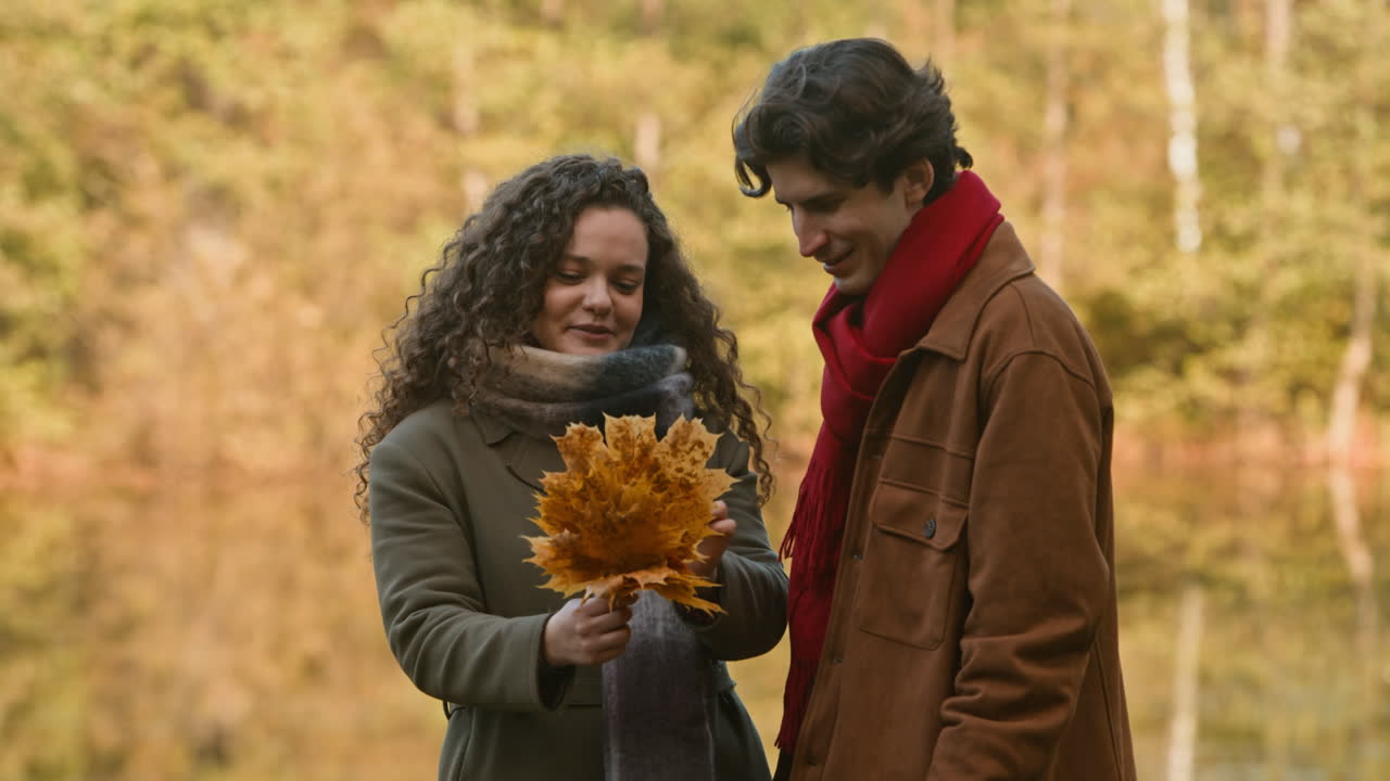 Couple enjoying autumn leaves in a park