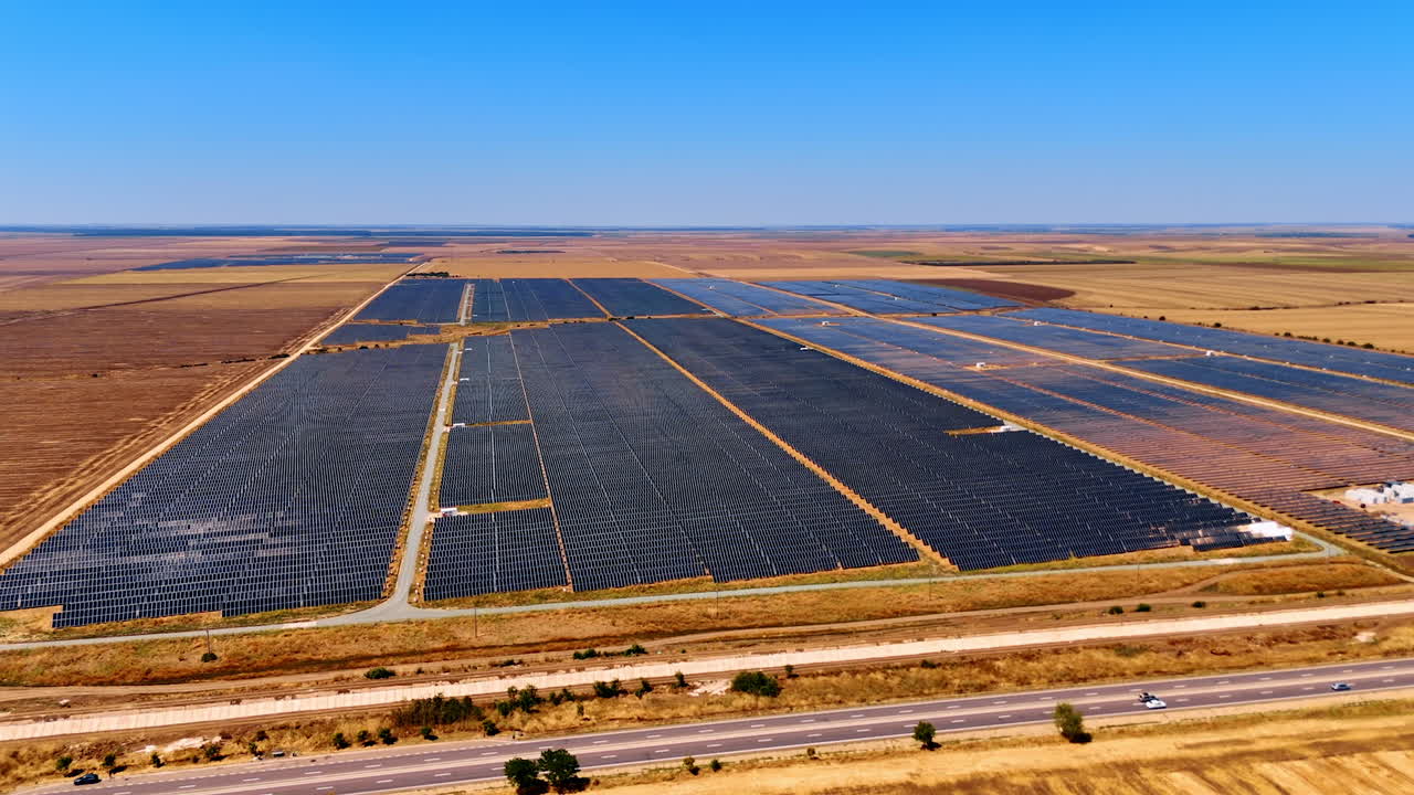 Distancing from the fields with multiple solar panels. Countryside used for green energy production. Aerial view
