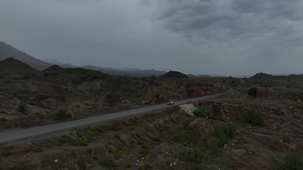 공중 드론  ⁇ 은 발로치스탄의 아름다운 산악 풍경에서 고속도로에서 운전하는 트럭을 추적합니다.