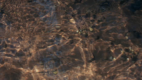 close up time lapse of a clear water stream , showing ripples and reactions, while gradually getting darker