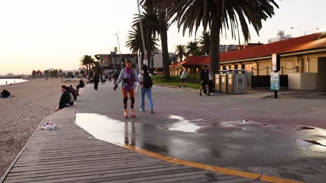 persona patinando a lo largo del camino de la playa de st. kilda