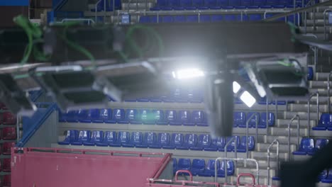 Empty-stadium-seats-and-glowing-lights,-pan-right-view