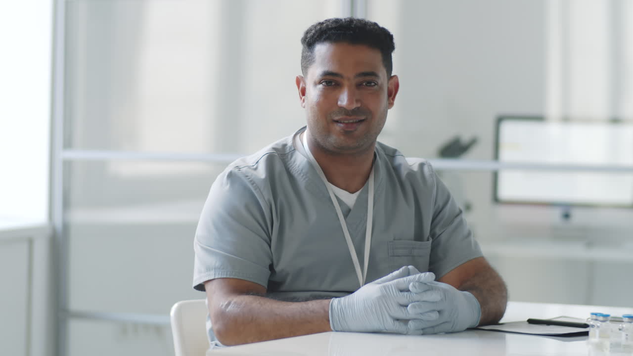 Positive Middle Eastern Male Doctor Posing for Camera at Work