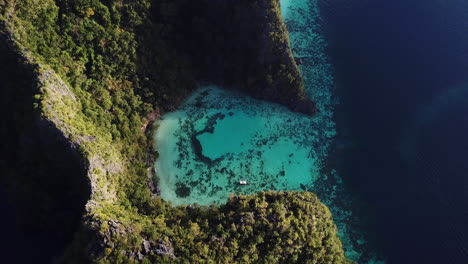 dramatic aerial reveal of vibrant blue ocean surrounding coron island, philippines