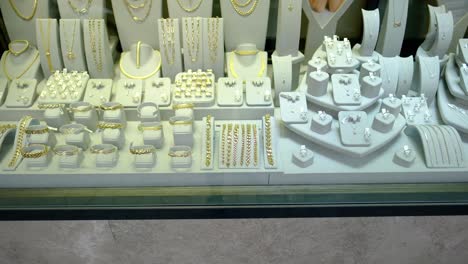 there are gold earrings and jewelry in the jewelry store window jwe