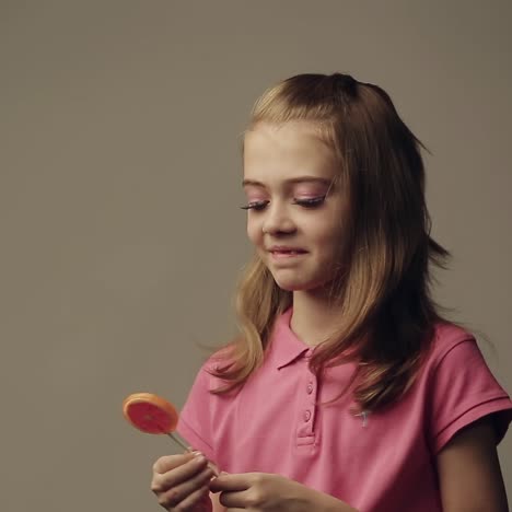 una chica lamendo caramelos de piruleta
