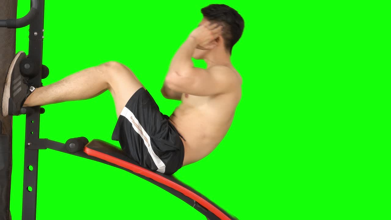 근육질의 남자가 체육기 위에 앉아 있습니다.