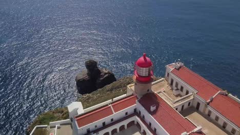 light tower in south of portugal next to ocean , view by drone