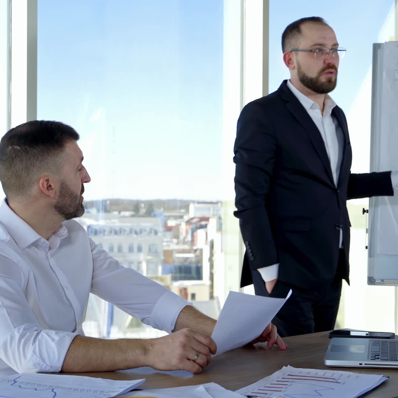 Male colleagues cooperating in office. Businessmen coworkers discussing together at workplace business project. Work of two employees making new ideas