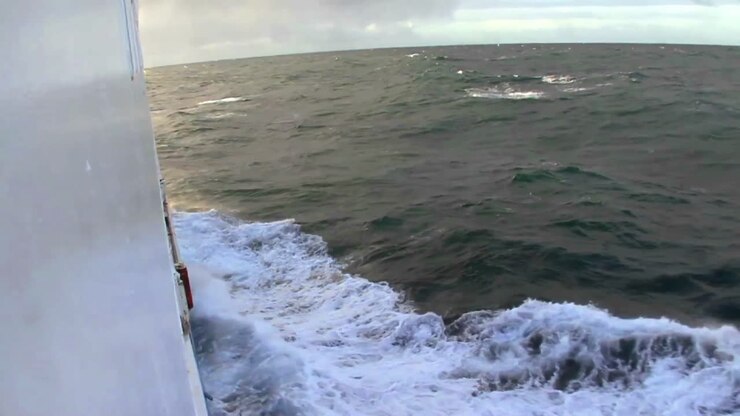 A ship plows through high seas