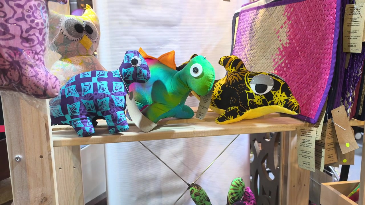Morbidi giocattoli animali colorati, realizzati con autentico tessuto batik malese, sono esposti in vendita. Queste simpatiche bambole presentano motivi tradizionali unici. Sono souvenir perfetti per i turisti