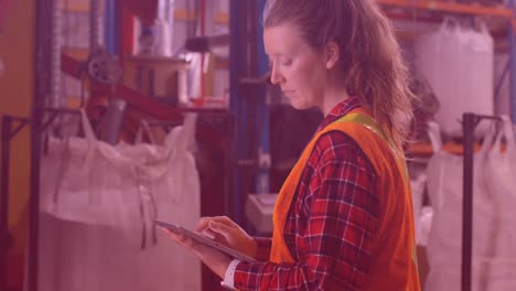 Animation-of-caucasian-female-worker-using-tablet-in-warehouse