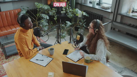 african american man giving interview to female journalist in podcast studio