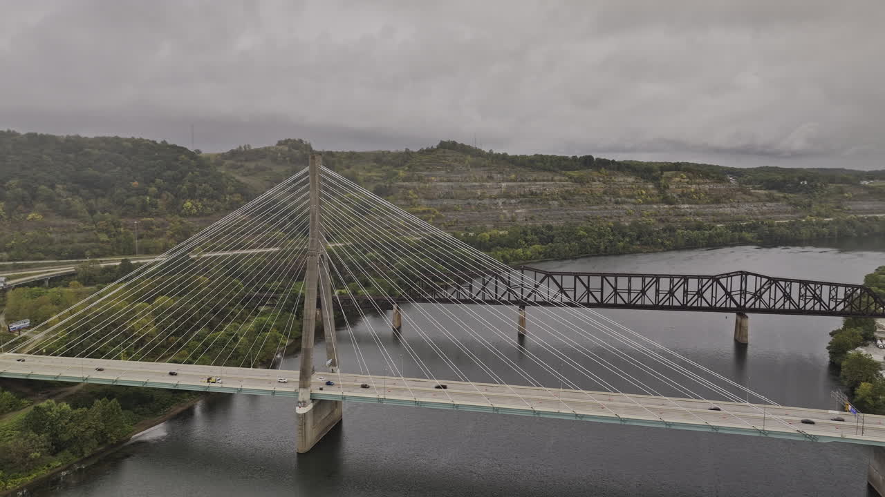 Steubenville Ohio Aerial v5 flyover and around a cable-stayed bridge alongside a truss bridge, spanning a calm river amidst rolling hills and a small town - Shot with Mavic 3 Pro Cine - Sept 22nd 2023