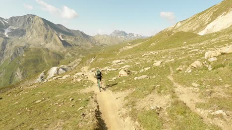 Mountainbiker-Auf-Einem-Natur-Singletrail-Mit-Riesigen-Bergen-Und-Klippen-Im-Hintergrund