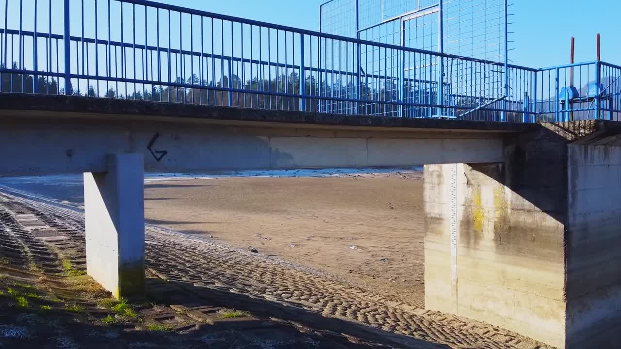 Drone flying along the steep edges and under the lake side bridge