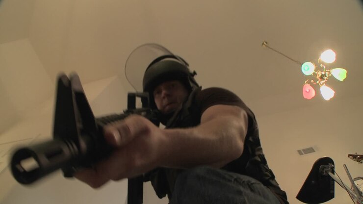 A SWAT team with DEA officers clears a house during a drug raid and holds a suspect at gunpoint 1