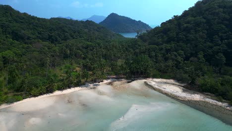 lush double mountain island with beach surrounded by turquoise sea and blue skies. marvelous aerial view flight overflight flyover drone
