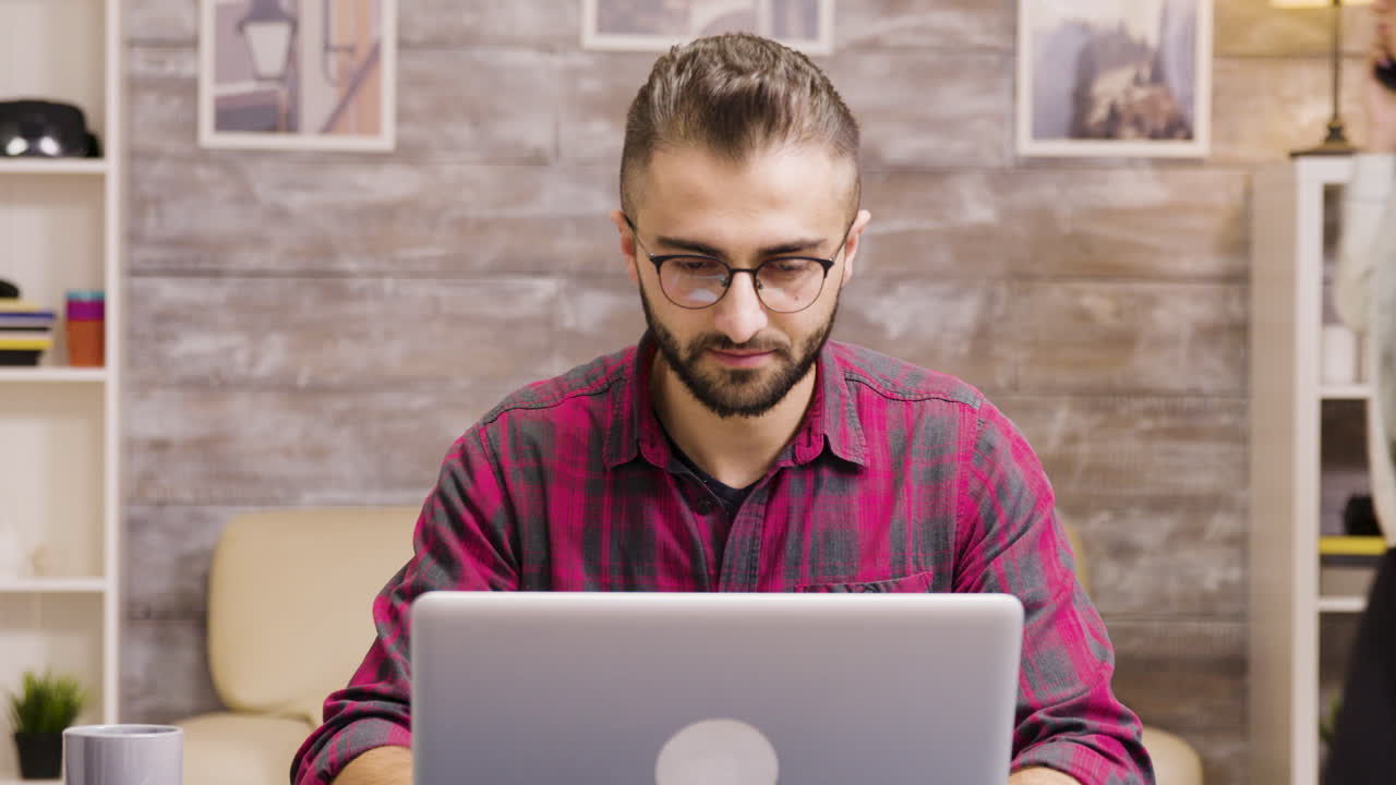 hombre trabajando en una computadora portátil en casa