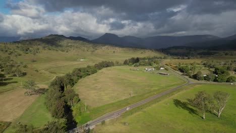 vistas aéreas sobre tierras de cultivo en lamington en el borde escénico con la lluvia cayendo en la distancia, queensland, australia