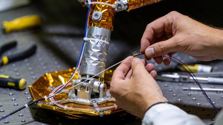 Grabbing connector labsleeve tech hands aligning wires and seating pins for assembly by foil arm