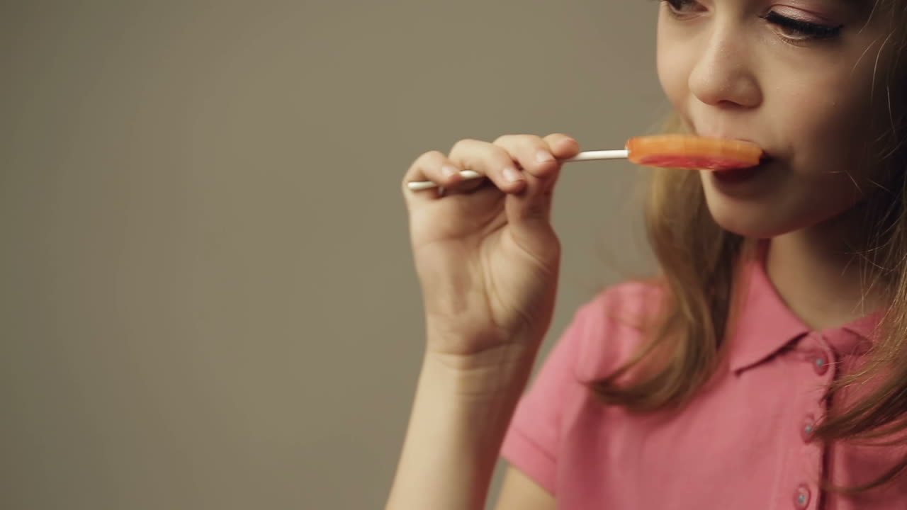 Beautiful little girl with candy, studio shot