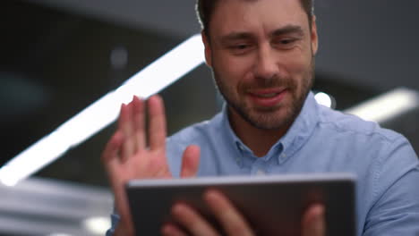consultor feliz usando tableta liderando una reunión de video en línea en un lugar de trabajo remoto.