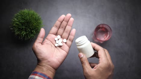 person taking pills from a bottle