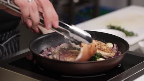 chef frying chicken breast with vegetables