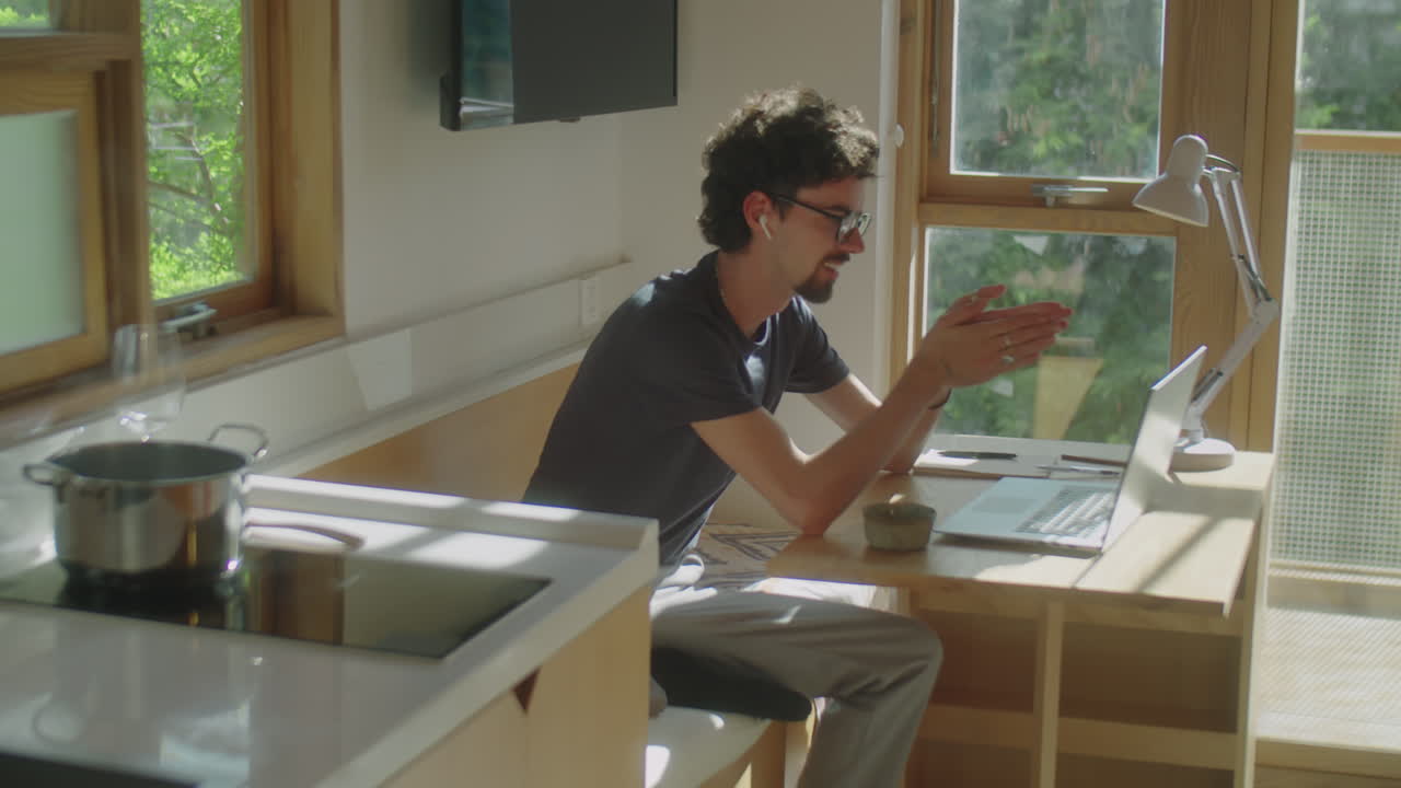 Man Chatting via Web Call on Laptop at Home