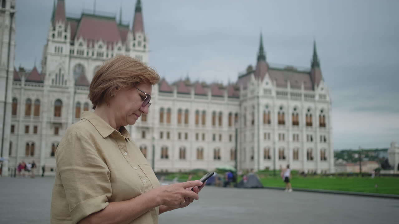 가리 의회 건물 앞에서 전화를 사용하는 여성