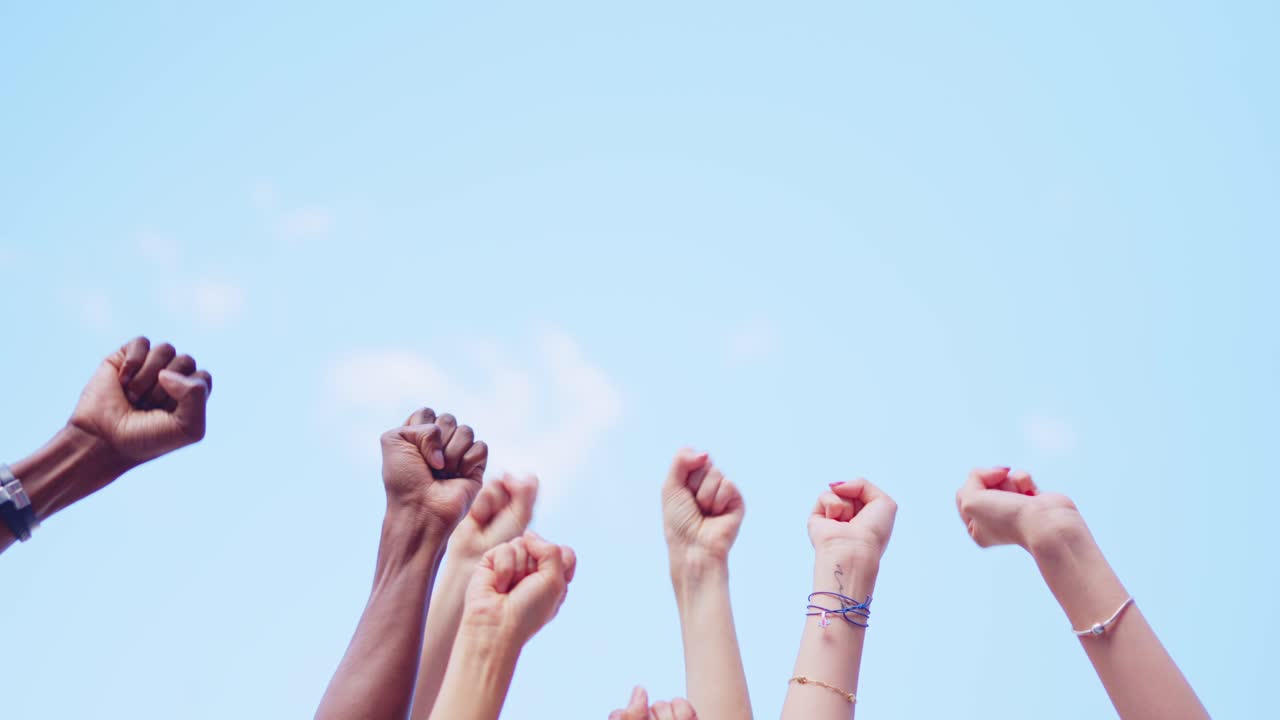 Diverse Fists Raised in Protest Against a Blue Sky