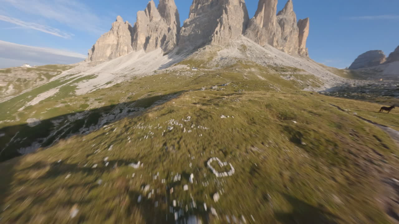 hermosa escena de caballos salvajes en verdes prados de dolomitas con picos de montañas rocosas en el fondo, italia