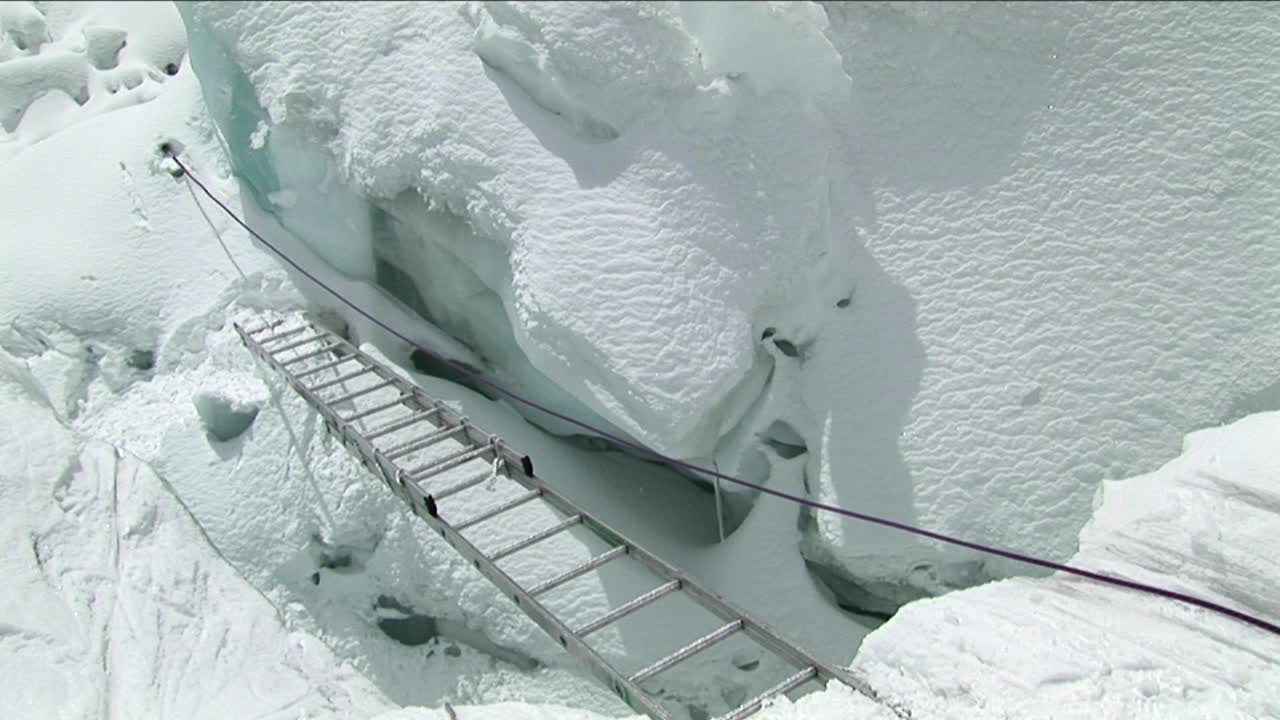 로프를 사용하여 짧은 사다리를 건너는 등반가